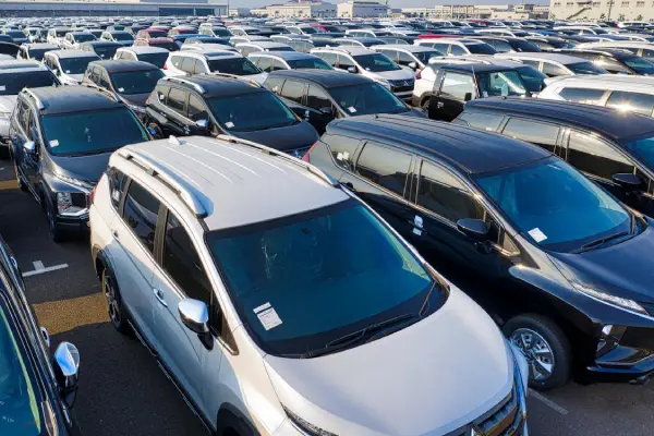 Free Modern sparkling clean new automobiles on asphalt parking near factory of manufacture in daytime Stock Photo