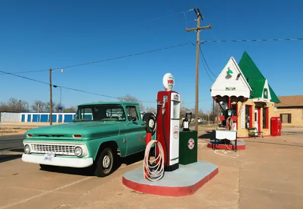 Free A retro gas station with a vintage truck and bright blue skies, ideal for travel nostalgia. Stock Photo
