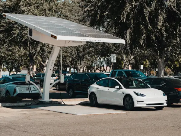 Free Electric car parked at a solar charging station outdoors, highlighting renewable energy and innovation. Stock Photo
