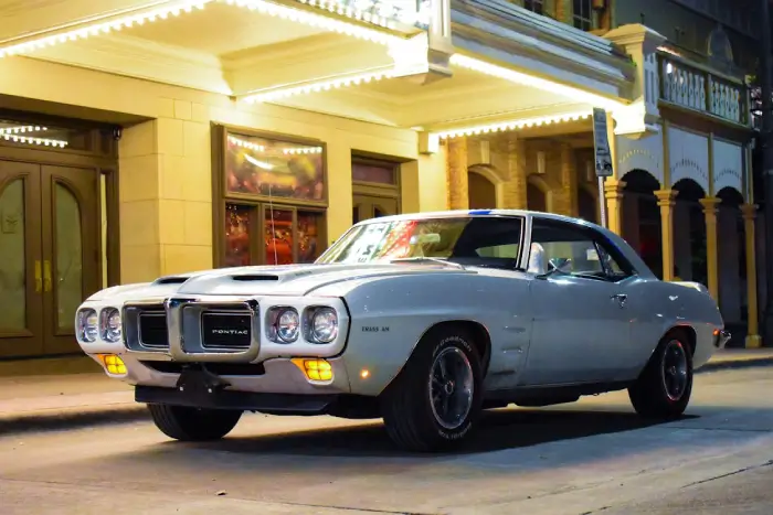 Free Vintage Pontiac Firebird Trans Am parked on a lit street at night. Stock Photo