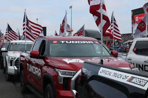 Free Toyota Tundra trucks in an American flag parade at a motorsport event. Stock Photo